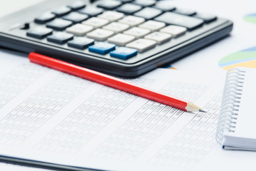 Business financial documents, office calculator and pen on the table. Numbers and graphs