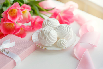 postcard. Marshmallows, pink tulips, satin ribbon on a white background
