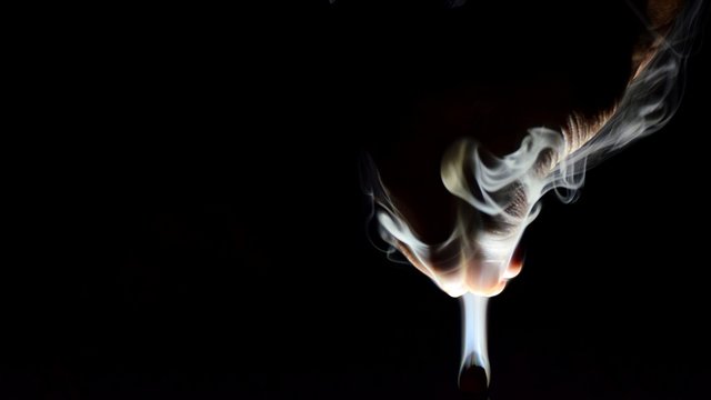 Cropped Hand Of Person Amidst Smoke Against Black Background