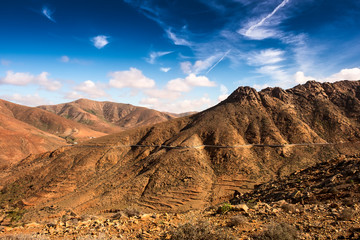 Volcanic mountains panorama with rocky desert terrain , blue cloudy sky, Fuerteventura, Canary Islands, Spain .