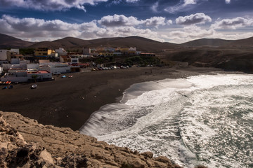 Black sand volcanic beach with wavea near fishing village Ajuy in Fuerteventura, Canary Islands,...