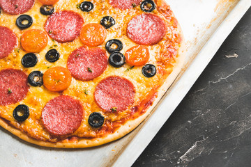 Fresh pepperoni pizza served on the rustic background. Selective focus. Shallow depth of field.