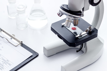 Laboratory examination with microscope. Equipment with blood sample on white background