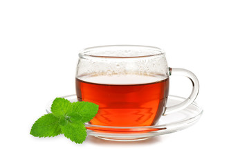 Studio shot of a glass cup of tea with mint leaf isolated on a white background in close-up