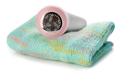 Modern fabric shaver and clothes on white background