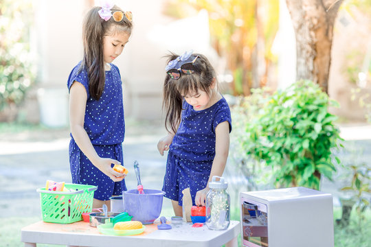 Close-up background view of cute Asian girls,who are experimenting with cooking or mixing food colors, concepts of learning to live life in a family,and studying new perspectives outside of the class