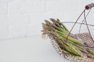 Obraz premium Fresh raw green asparagus in a metal vintage basket