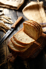 Bread on a wooden background, eggs, flour in a bowl, rye, bread knife, cereals