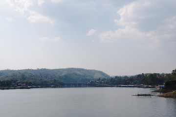 warm country lake, bridge and low-rising mountains
