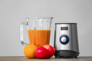 Modern blender with smoothie and products on table