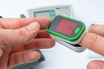 Pulse Oximeter, finger digital device to measure person`s oxygen saturation. Close-up. Reduced oxygenation is an emergency sign of pneumonia. Prevention and diagnosis of mers covid 19