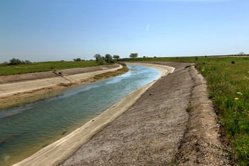 Fototapeta na wymiar Crimea, Russia, 2014: Rice irrigation canal after fresh water inflow plate from mainland Ukraine. Water Crimea blockade Artificial drought, collapse of agriculture irrigated agriculture