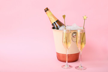 Bucket with ice and champagne on color background © Pixel-Shot