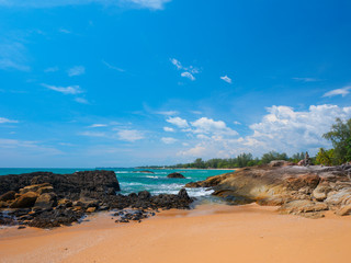 Uninhabited tropical rocky beach with blue sky