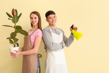 Portrait of florists with plant on color background