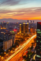 Warm sunset over a modern city with a lot of traffic