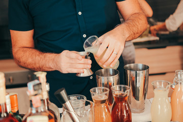 The expert bartender is making a cocktail at the bar. Man preparing cocktails.