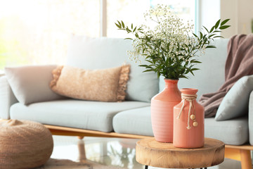 Vases with flowers in modern living room