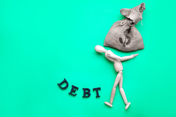 Mannequin, bag with money and word DEBT on color background