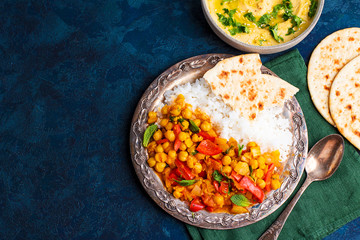 vegan food, hummus, rice, chickpeas with vegetables, pita bread on a blue background