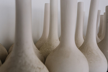 The old jugs are in the background of the white wall