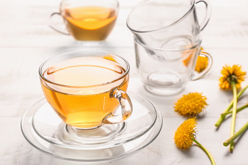 Cup of healthy dandelion tea on wooden background