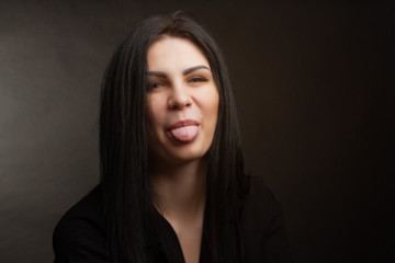 Naklejka premium brunette girl in black shirt on grey background. Straight hair hairstyle