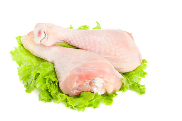 Raw chicken legs and green salad isolated on white background