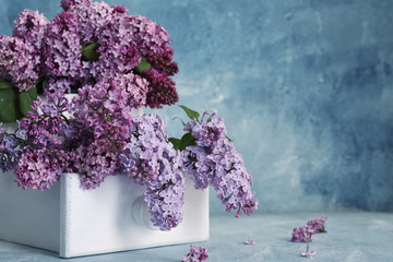 Box with beautiful lilac flowers on table