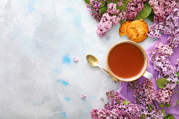 Beautiful lilac flowers, tea and cookies on table