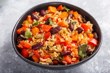 brown rice with vegetables on a grey background