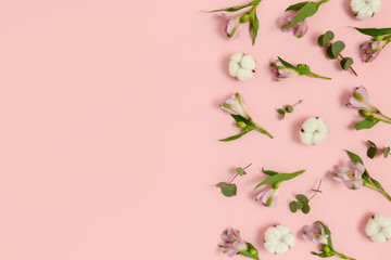 Obraz na płótnie Canvas Pattern made of eucalyptus, cotton, alstroemeria flowers on a pink pastel background. Spring concept with copy space.