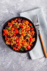 brown rice with vegetables on a grey background