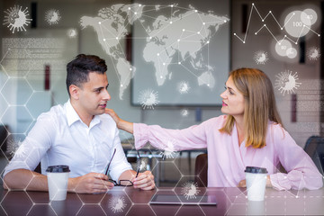 Woman tapping man on shoulder and virtual pandemic graphics. Young Caucasian businesswoman sitting at table with male manager, consoling or supporting him. Business relationship concept