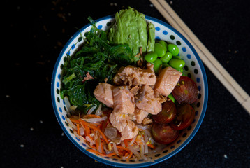 bowl of homemade salmon (avocado, salmon, wakame, edamame, cherry tomato and rice), top view. Poke.