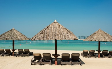 Beach sunbeds and cabanas on the sand, sea view, luxury beach holidays