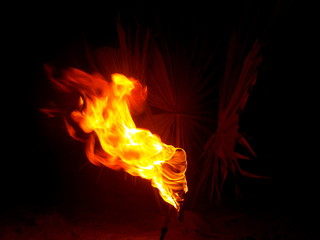 Burning torch on the beach at night