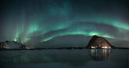 polar lights also called northern lights or aurora borealis in northern norway during winter above a fjord and snow covered mountains