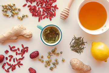 A cup of herbal tea with lemon, honey, goji and ginger as a healthy life style and health care concept, natural treatment for colds, flu and virus fever.