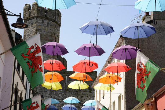 Coloured umbrellas and Welsh flags fly in the Royal town of Caernarfon in North Wales