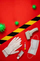 test tube with a virus test, gloves, mask, thermometer, antibacterial hand spray, green coronavirus model on a red background. for storys. View from above. Antivirus protection. Vertical.