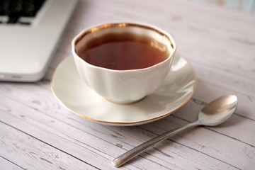 Cup of tea, Notepad and computer on the table