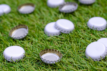 Pile of Discarded Beer Bottle Tops on Grass