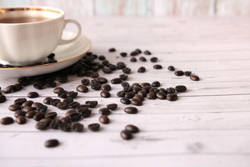 A Cup of black coffee and coffee beans scattered on the table