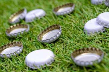 Pile of Discarded Beer Bottle Tops on Grass
