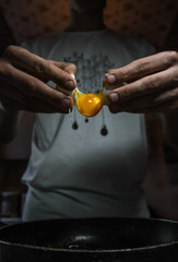 cook prepares an egg, breaking an egg
