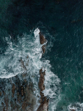 Aerial View Of Sea Waves Splashing On Rocks