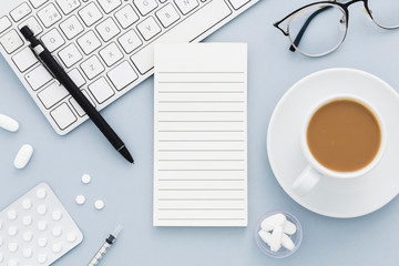 Coffee and medical equipment on desk top view blue