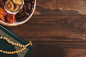 plate of dried fruit, wooden rosary, Koran on brown wooden background, iftar concept, Ramadan,...