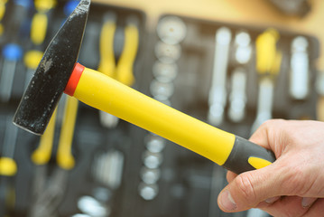 Man holds hammer on the tool case background